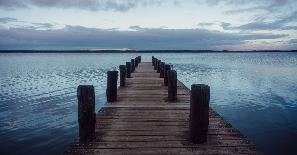 Steg geht auf einen See hinaus in der Dämmerung